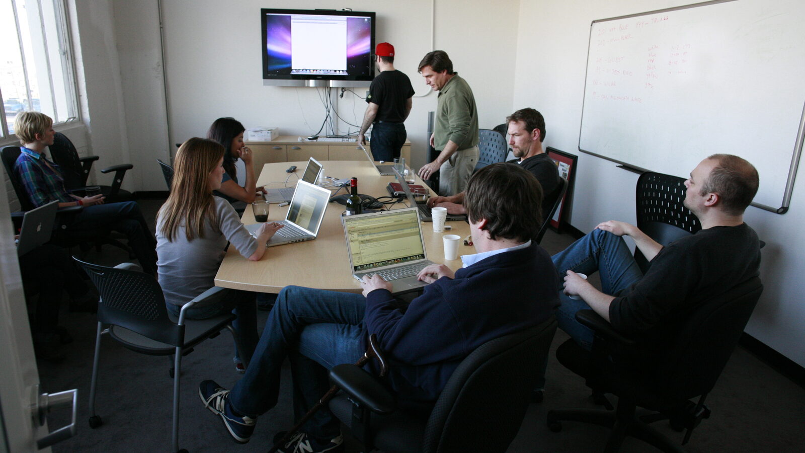 Enterprise technology team meeting with laptops